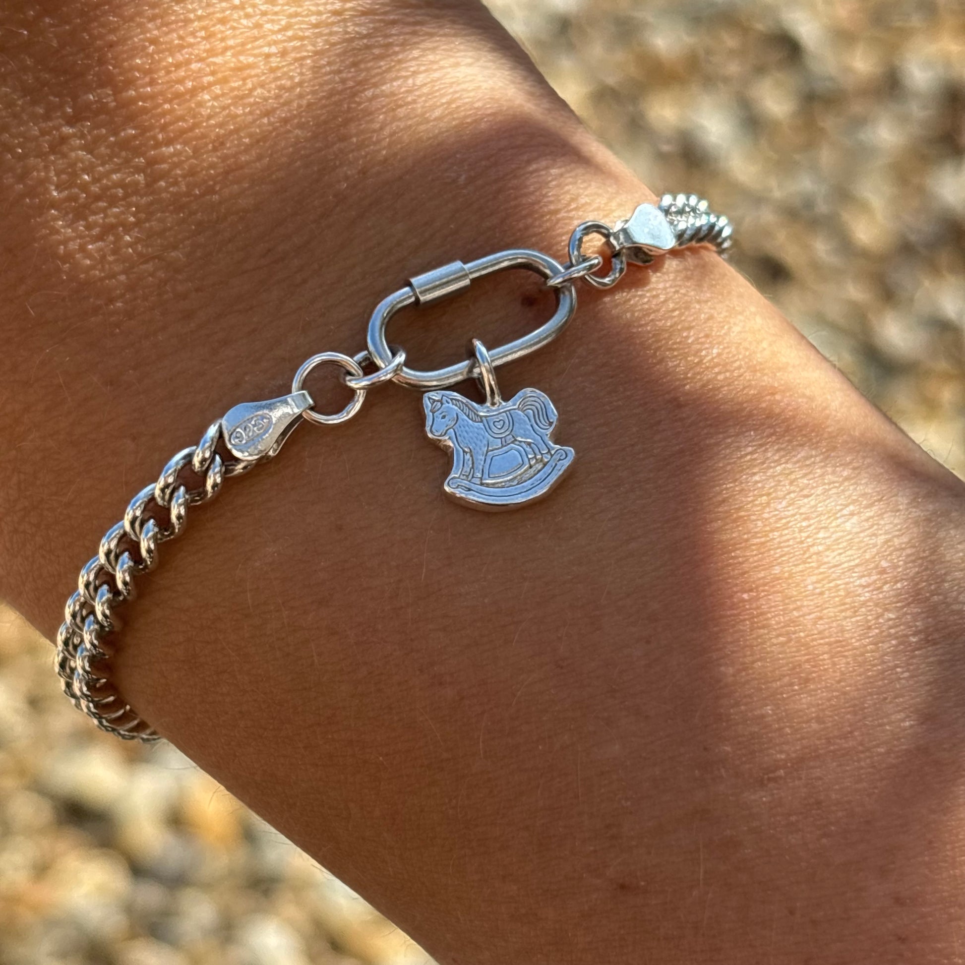 Silver curb chain bracelet with silver rocking horse charm