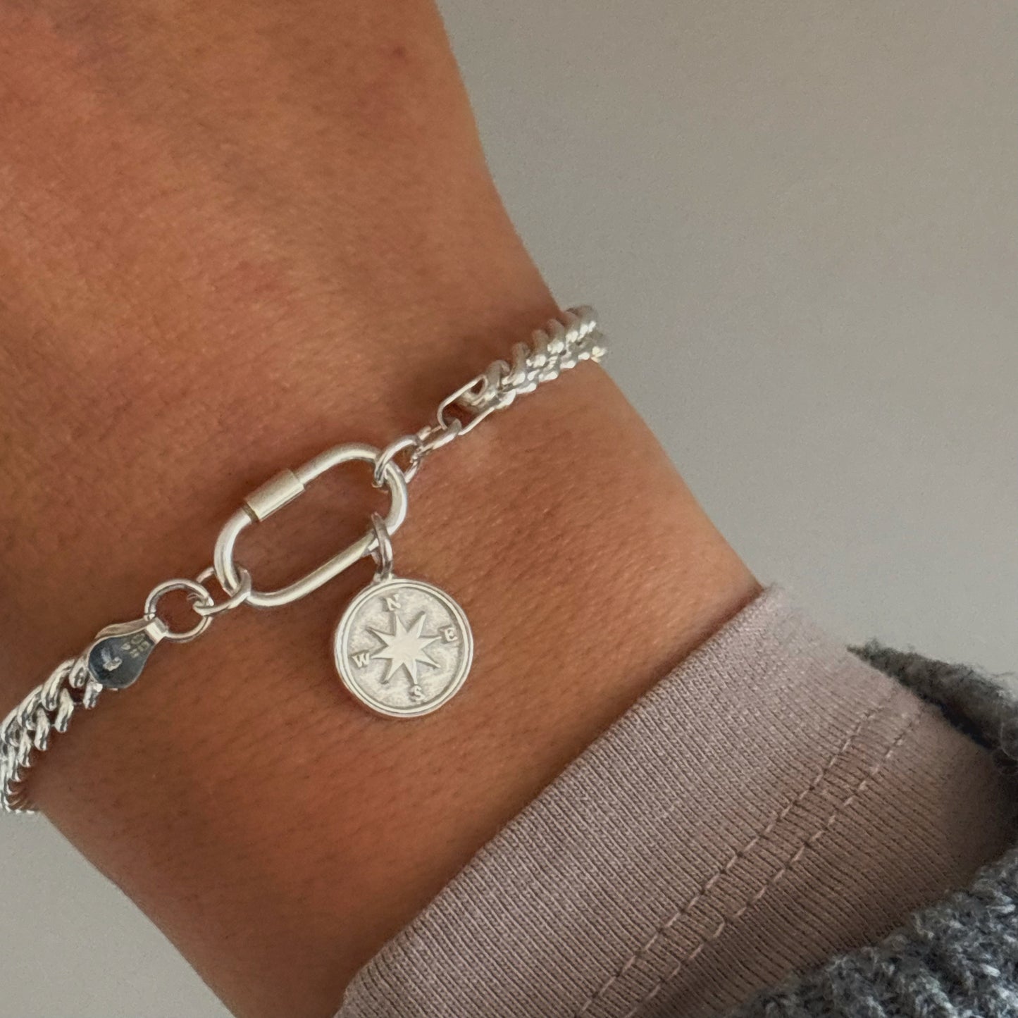
Sterling silver compass charm bracelet on curb chain with carabiner clasp, handmade in Sussex