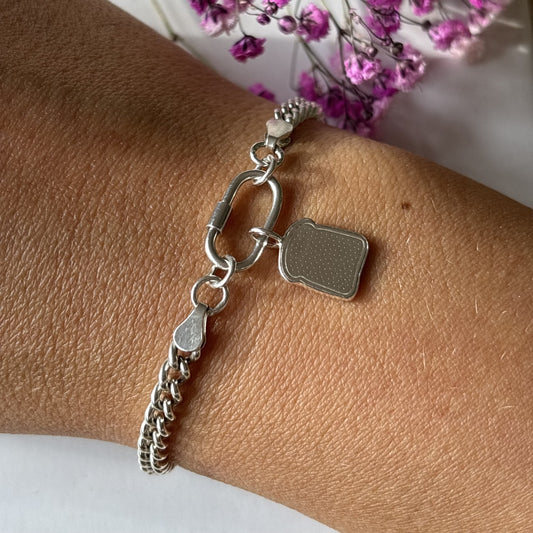 Handmade silver toast charm bracelet on wrist