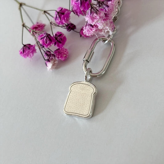 Silver slice of toast charm surrouded with flowers