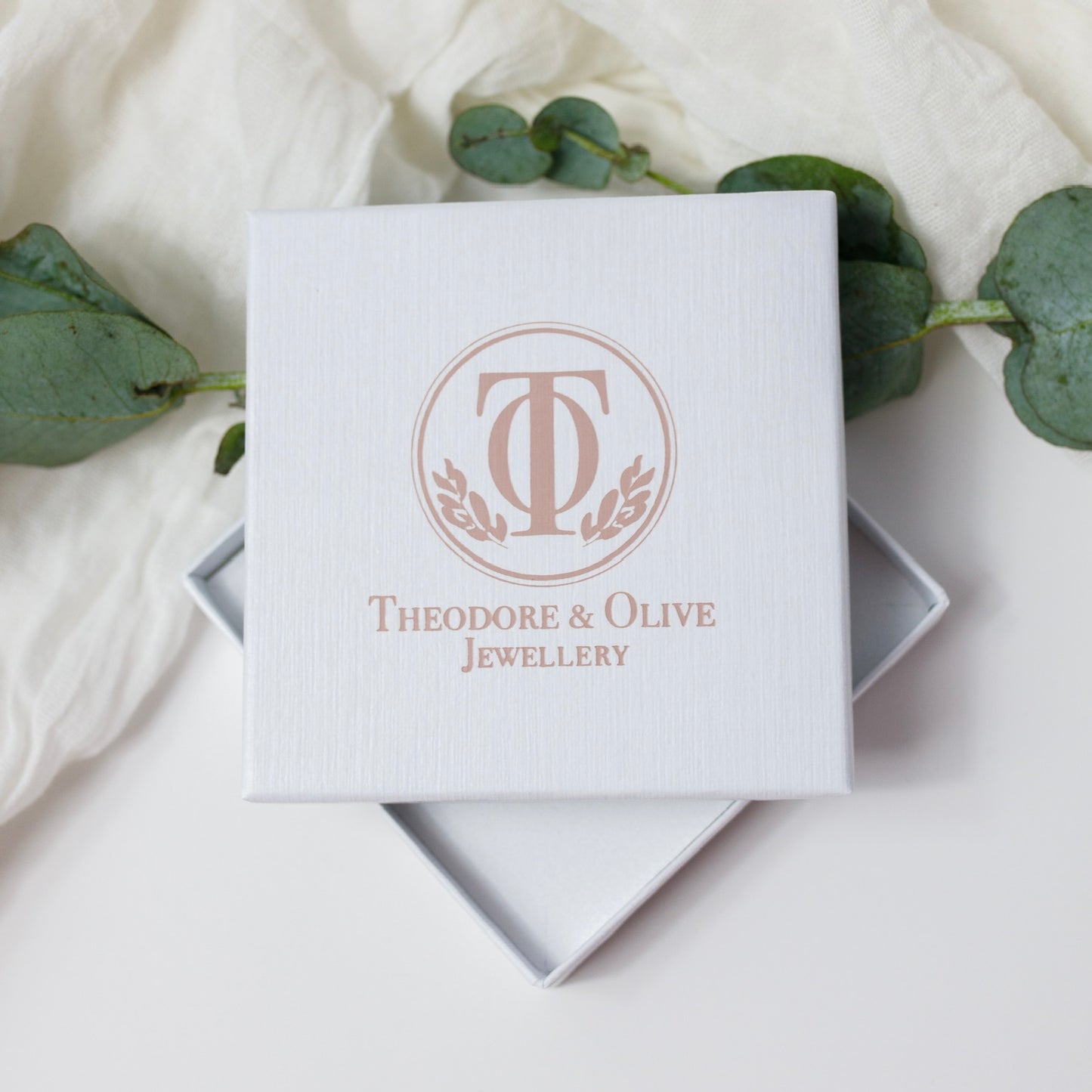 White Jewellery box with Theodore and Olive jewellery logo in pink on the front on a white background 