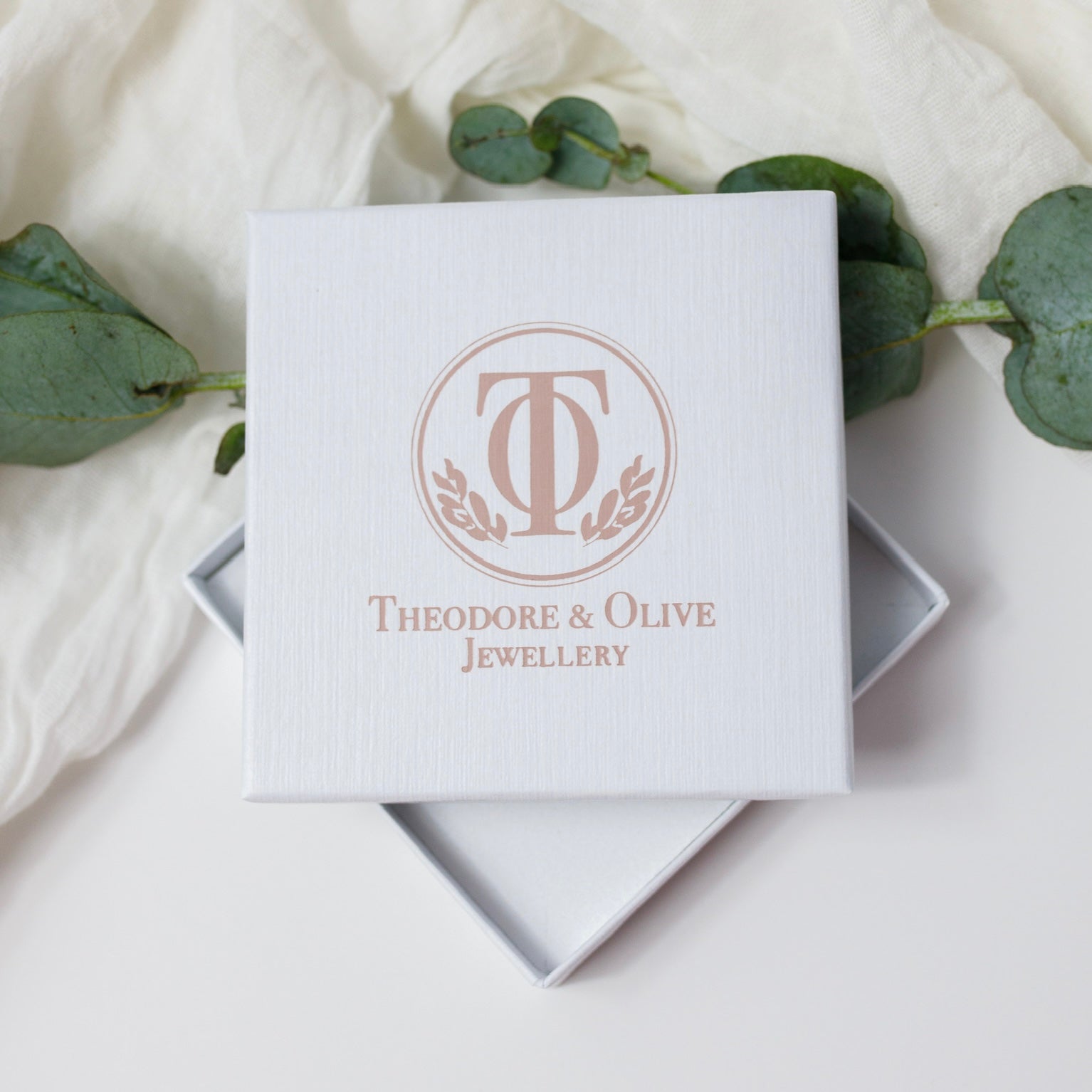 White Jewellery box with Theodore and Olive jewellery logo in pink on the front on a white background 