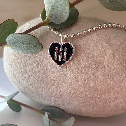 Sterling silver ball chain with sterling silver and black enamel heart charm with three sterling silver candles 