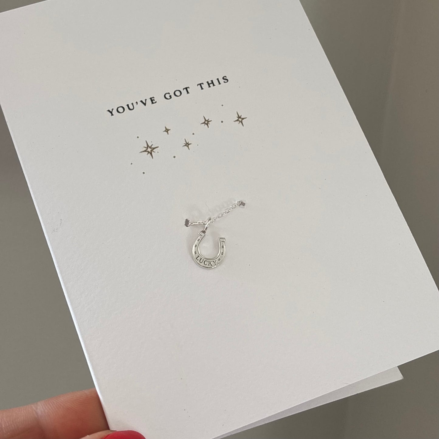 Greeting card with “you’ve got this printed on the front” pairs with a sterling silver bracelet and charm help by a hand 