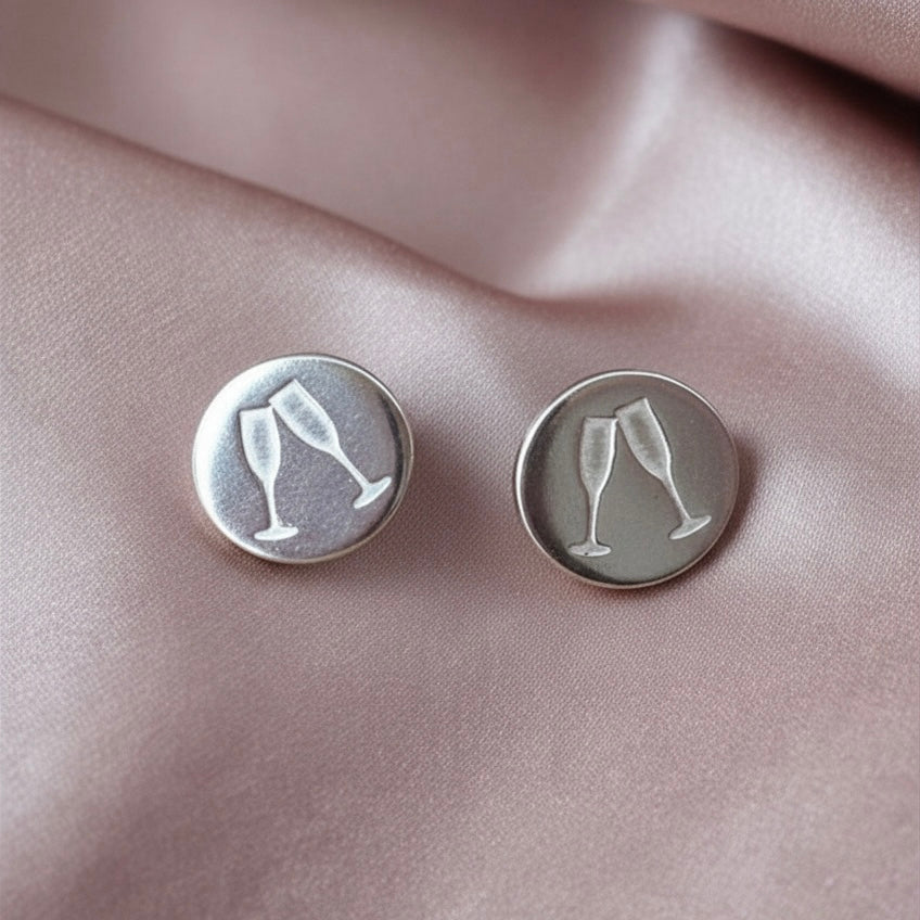 sterling silver champagne glass stud earrings on pink fabric background