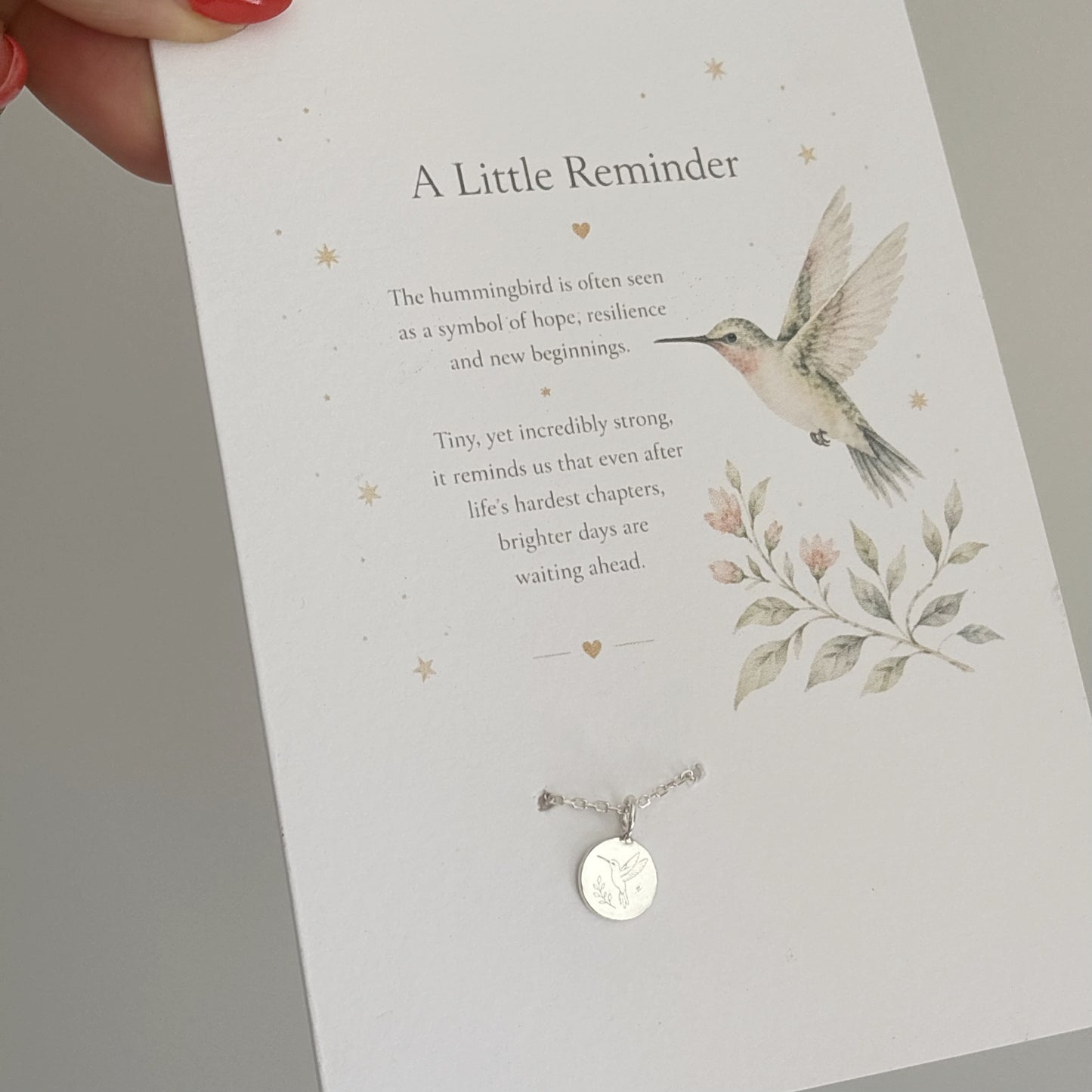 Card with a hummingbird illustration and necklace, featuring a message about resilience and hope.