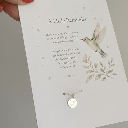 Card with a hummingbird illustration and necklace, featuring a message about resilience and hope.