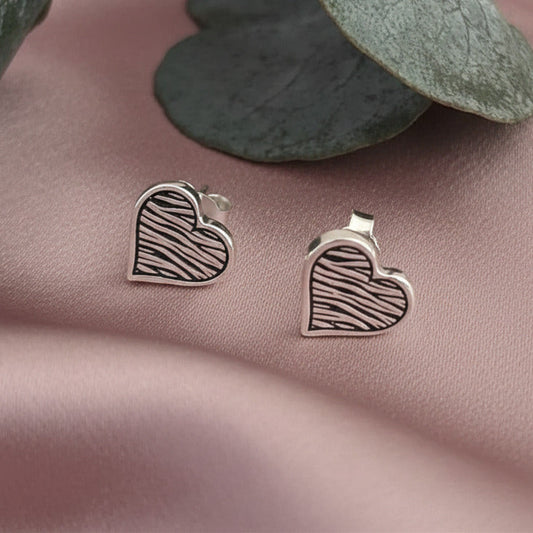 Silver zebra print heart studs laid on dusky link satin