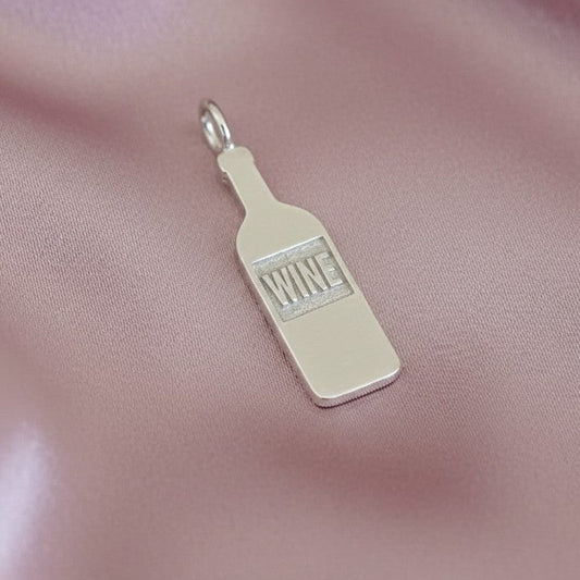 Silver ‘WINE' bottle charm on a pink satin background