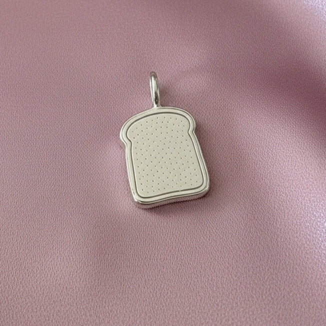 Toast-shaped pendant on a pink fabric background